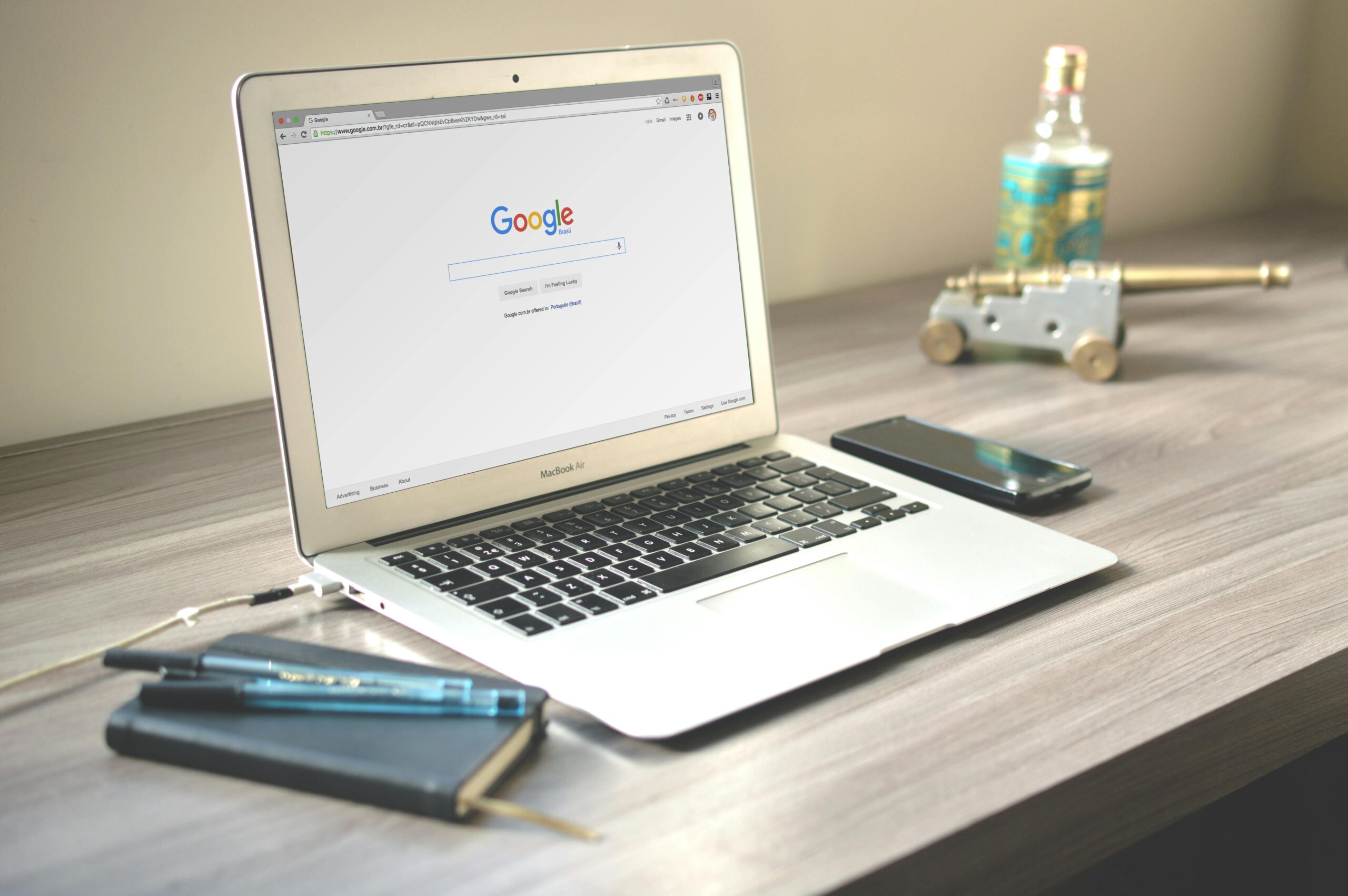 A neat workspace featuring a laptop displaying Google search, a smartphone, and a notebook on a wooden desk.How to Choose the Right Digital Marketing Services for Small Business